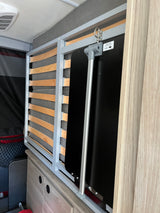 RV rental interior shows a folded bunk bed frame and a table leg mechanism, optimizing space for travel adventures.