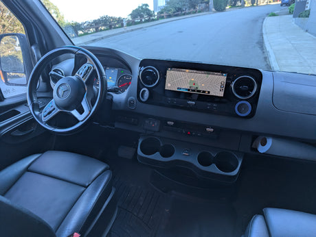 RV rental van interior: Modern Mercedes dashboard with a large navigation screen showing San Francisco, AUXBEAM panel, and cupholders.
