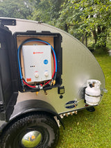 Camplux outdoor hot water heater in a teardrop camper, showing portable propane setup. Great for rv rental camping!