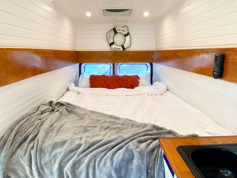 RV rental: Cozy camper van bedroom with comfortable bed — photo 1