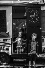 An RV rental brings joy: Kids play around a pop-up camper, with one boy making a silly face outside. "Happy Campers" chalkboard visible.