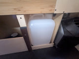 RV rental: Water jug stored in a wooden compartment, providing essential utility for camper living.