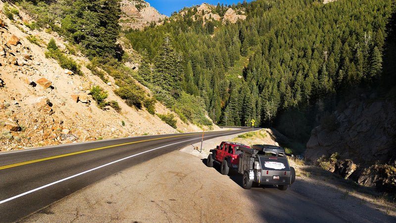 A red Jeep towing an overland trailer, an ideal RV rental for mountain adventures, parked on a scenic road. — photo 6