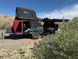Relaxing in an overland teardrop trailer with a rooftop tent. Perfect for your next rv rental adventure and camping trip.