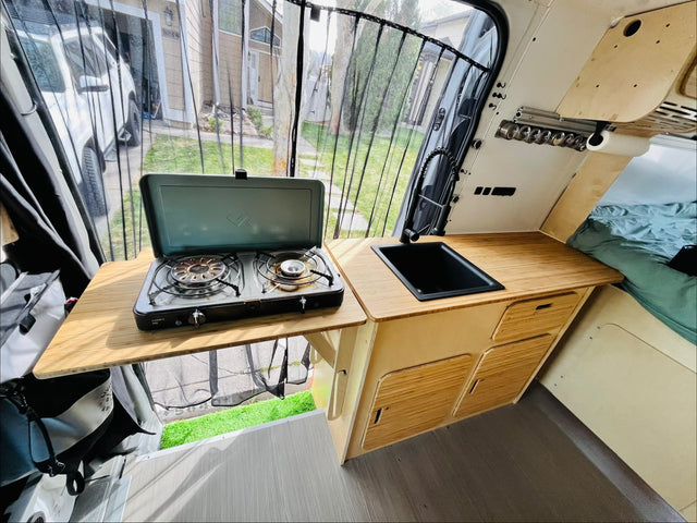  and a scenic outdoor view.|Cozy RV rental interior: kitchenette with bamboo countertops
