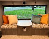 Comfortable RV rental dinette featuring plush seating, a central table, and a wide window for scenic views.