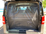RV rental van's rear hatch features a bug screen, revealing a cozy bed and an ocean view through the front.