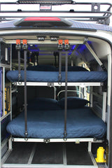 Modular bunk beds inside a custom RV rental, complete with power system & roof rack. Ideal for mobile adventures.