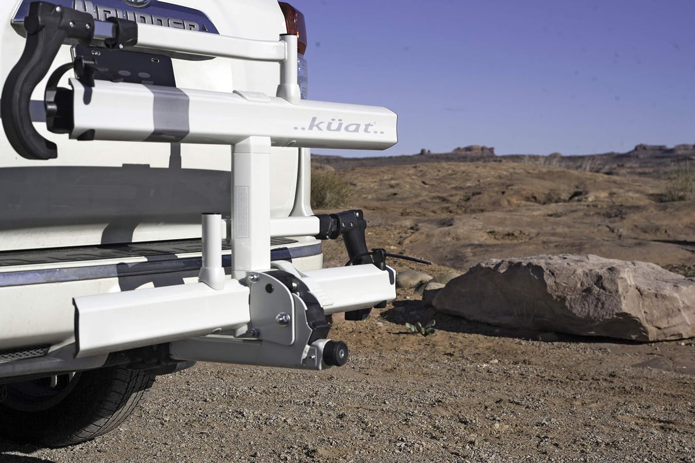 Vehicle's Kuat hitch bike rack, perfect for an rv rental outdoor adventure in rocky terrain.