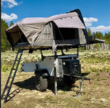 Discover this rugged off-road RV rental: an overland trailer with a deployed roof-top tent and front power unit for adventure camping.