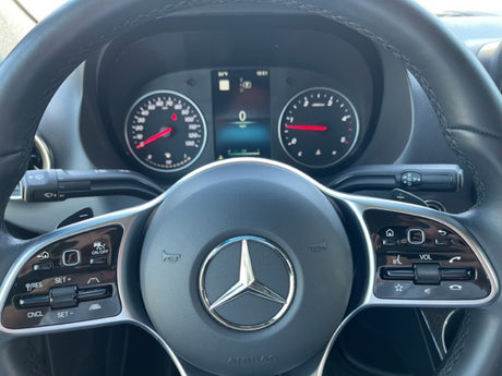 Mercedes-Benz RV rental driver's cockpit with dashboard, digital display, steering wheel controls, and shifter.