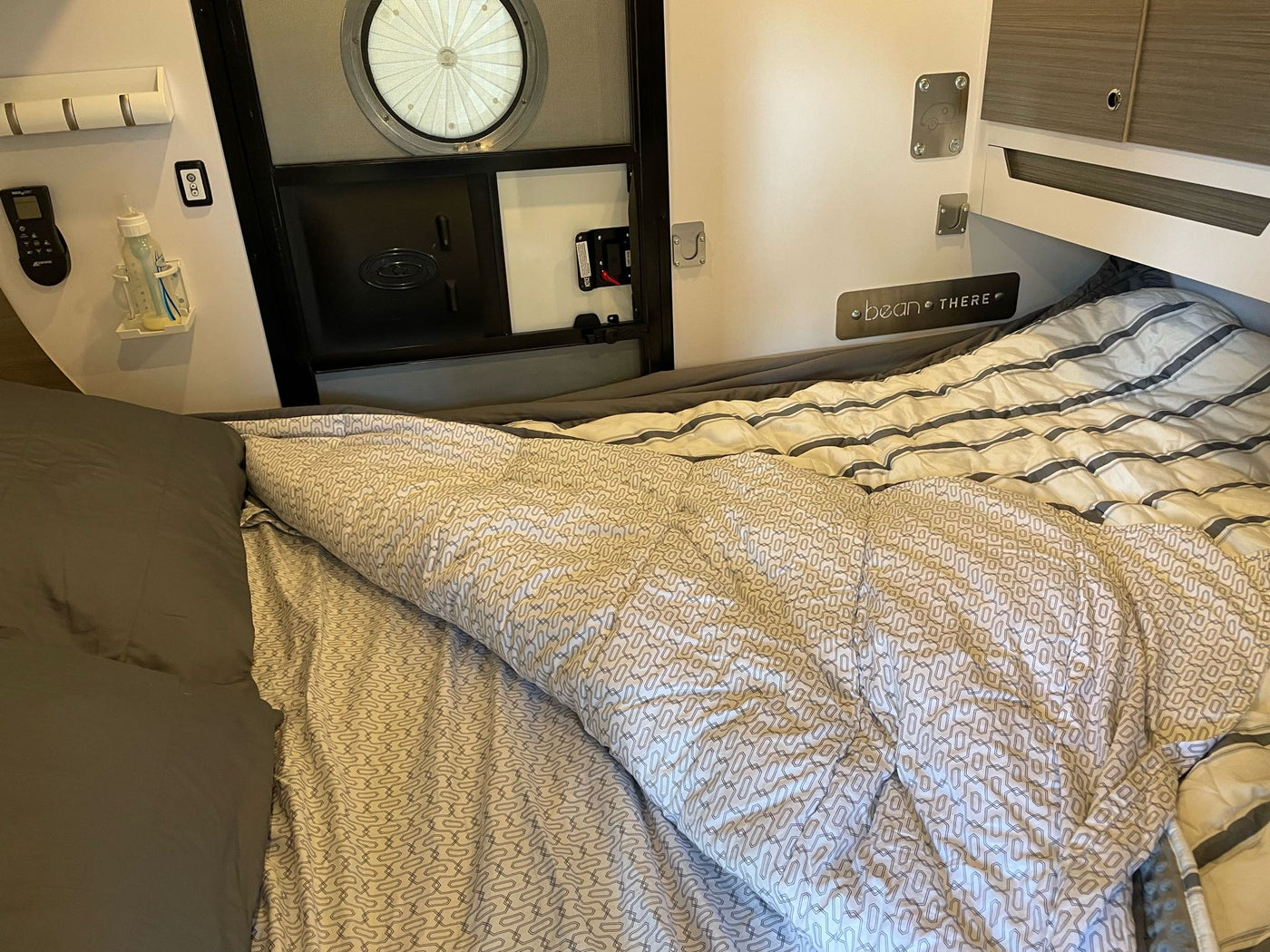  a girl and a baby relax on blankets. Cozy family camping fun!|Cozy RV rental interior with a comfortable bed — photo 7