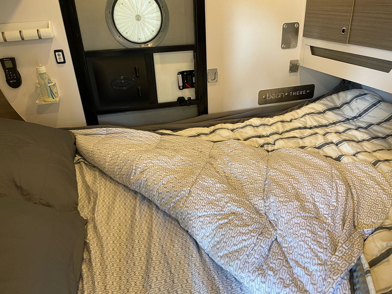  a girl and a baby relax on blankets. Cozy family camping fun!|Cozy RV rental interior with a comfortable bed — photo 7