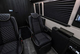 Luxury RV rental interior features premium black leather captain's chairs with diamond stitching and modern controls for comfortable travel.