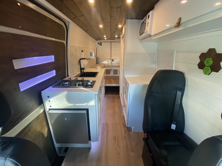  with its side door open to show the interior.|Open rear doors reveal the spacious interior of this RV rental — photo 13