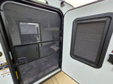 RV rental interior view: open screen door with outside visible, beside a window with a closed privacy blind.