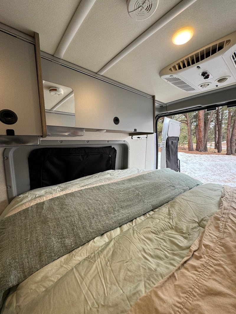 and utility panel for comfortable adventures.|An RV rental's cozy bed and interior — photo 15