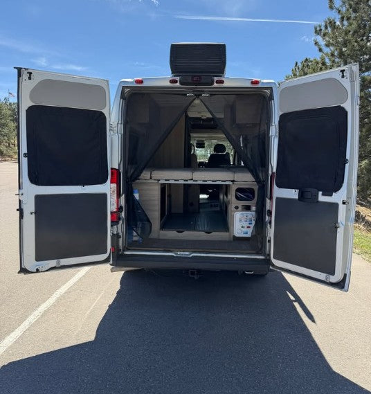 Rear view of an RV rental with open doors, a mesh screen, elevated bed, and interior ready for adventure. — photo 14
