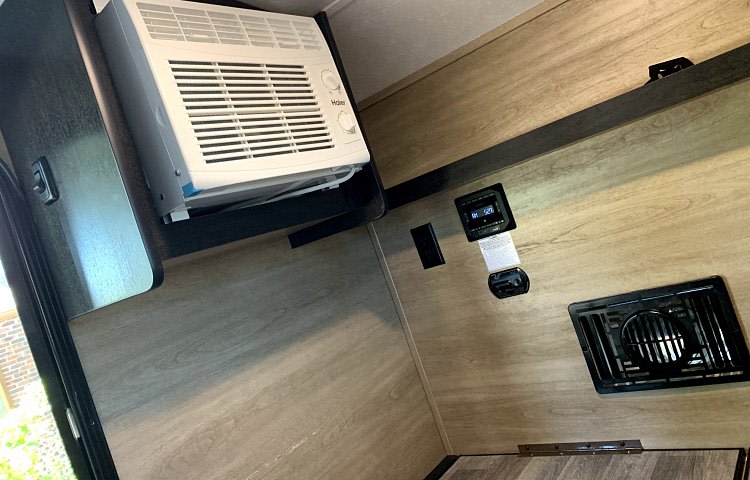 rv rental amenities: Haier AC, system control panel, and floor vent in a modern interior setup. — photo 19