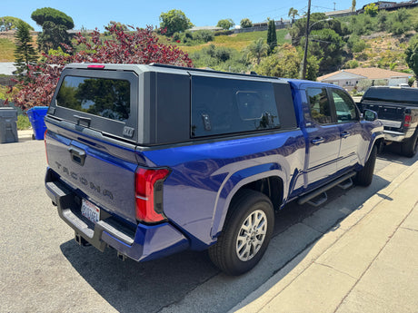 Blue Toyota Tacoma pickup truck with a SmartCap bed, perfect for gear on an RV rental vacation or camping trip.