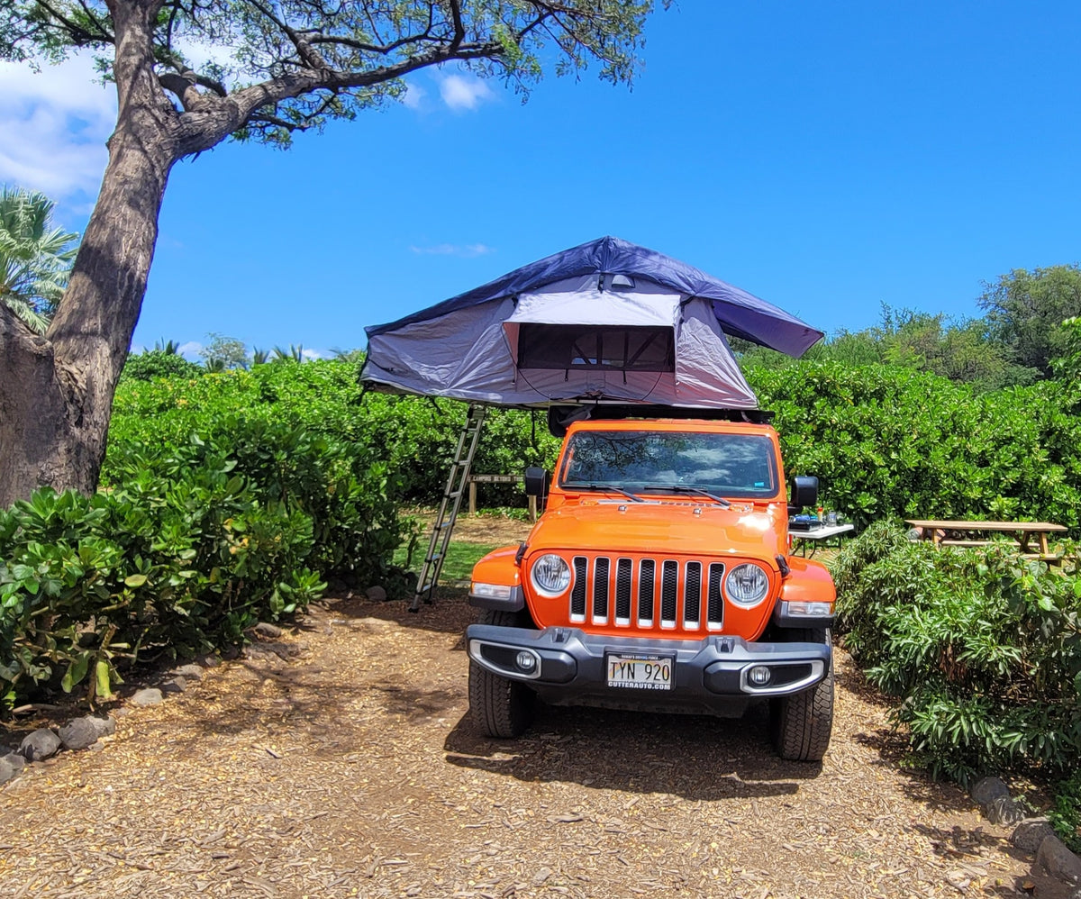 An orange Jeep Wrangler with a deployed rooftop tent, perfect for an adventurous RV rental camping trip. — photo 4