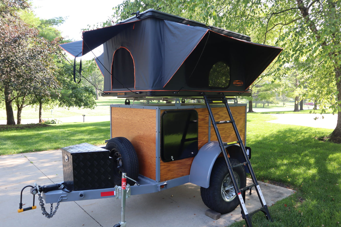 RV rental: Compact camper trailer with a deployed rooftop tent