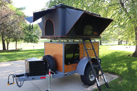 RV rental: Compact camper trailer with a deployed rooftop tent