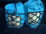 Two blue SZNJUK brand bags with palm tree logos are neatly stowed in a black net pocket, perfect for RV rental organization.