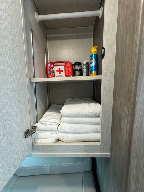 Well-stocked RV rental storage featuring a first aid kit, Pledge spray, and