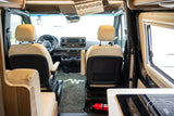 Interior of a modern RV rental: A clean cockpit features tan leather seats, a Mercedes-Benz dashboard, and a visible fire extinguisher.