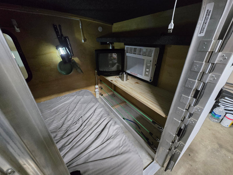  parked in a lot on a sunny day.|Cozy RV rental interior features a bed — photo 2