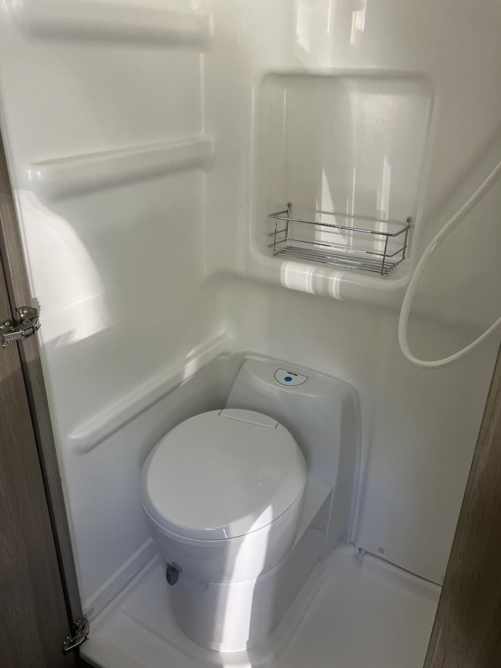 Inside an RV rental: a compact wet bath with integrated toilet and shower, ready for your travels.