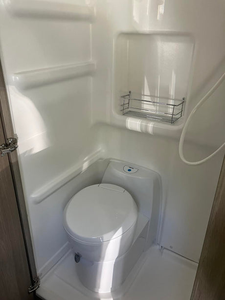 Inside an RV rental: a compact wet bath with integrated toilet and shower, ready for your travels.