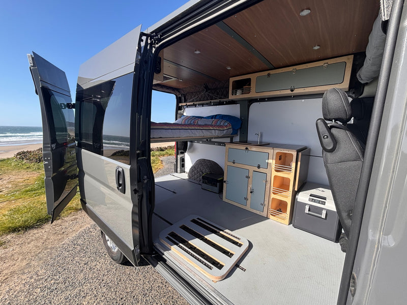 Enjoy beachside living in this rv rental camper van. Features include an elevated bed, kitchen, and ample storage. — photo 6