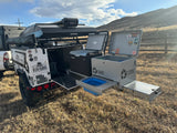 Explore with this robust overland trailer, ideal for RV rental-style adventures, featuring an outdoor kitchen & Dometic fridge.