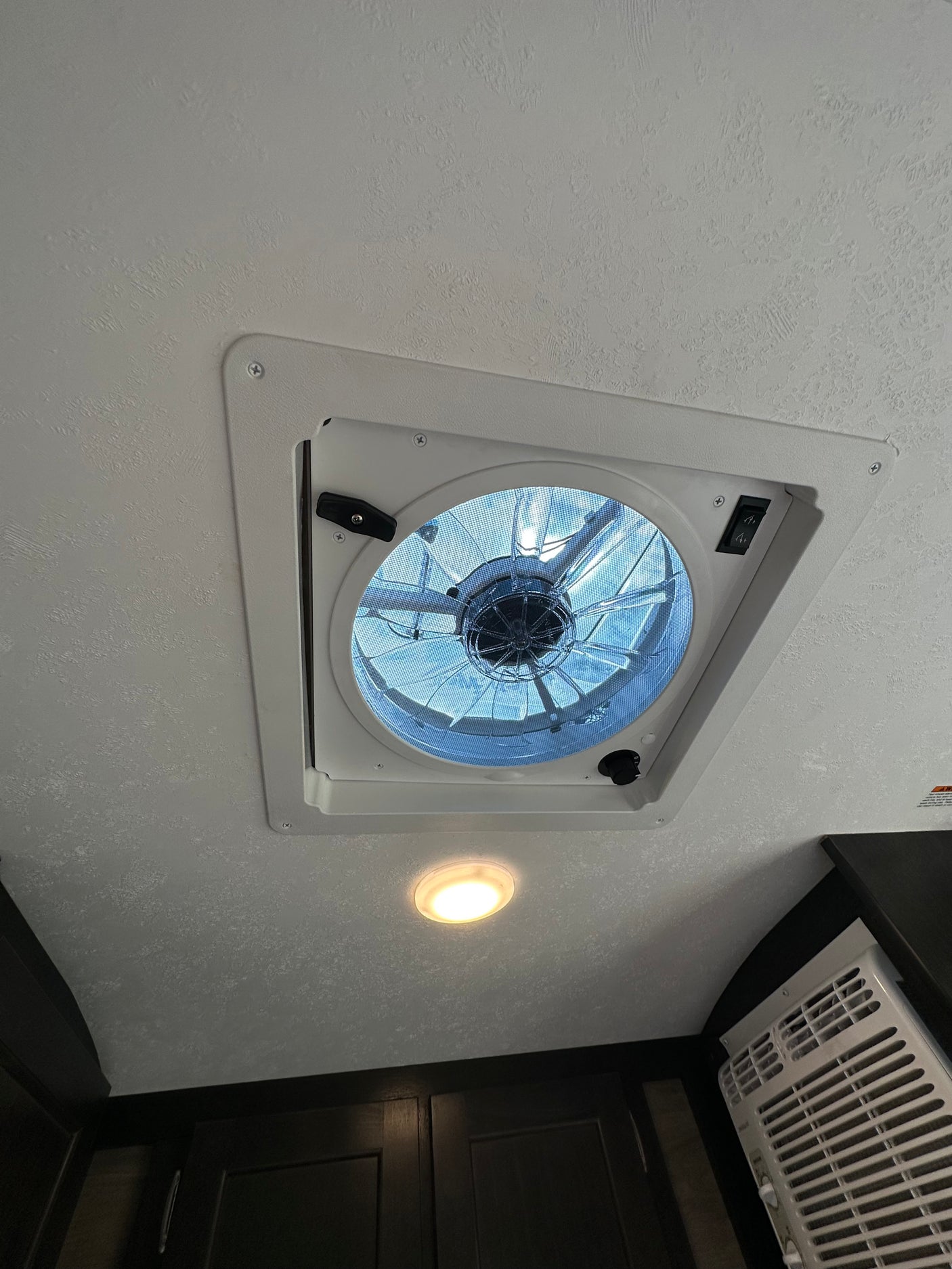 Inside an RV rental: Ceiling fan/vent, bright LED light, and AC unit provide comfort for your journey.