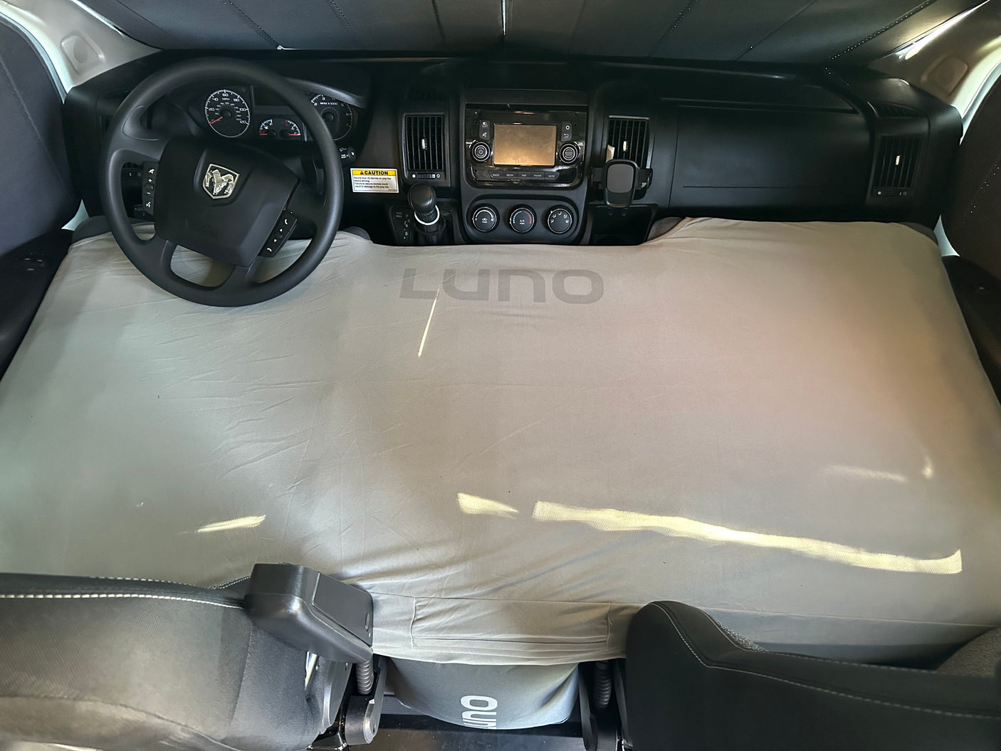 RV rental front cabin transformed into a sleeping area with a LUNO mattress covering the floor and dashboard.