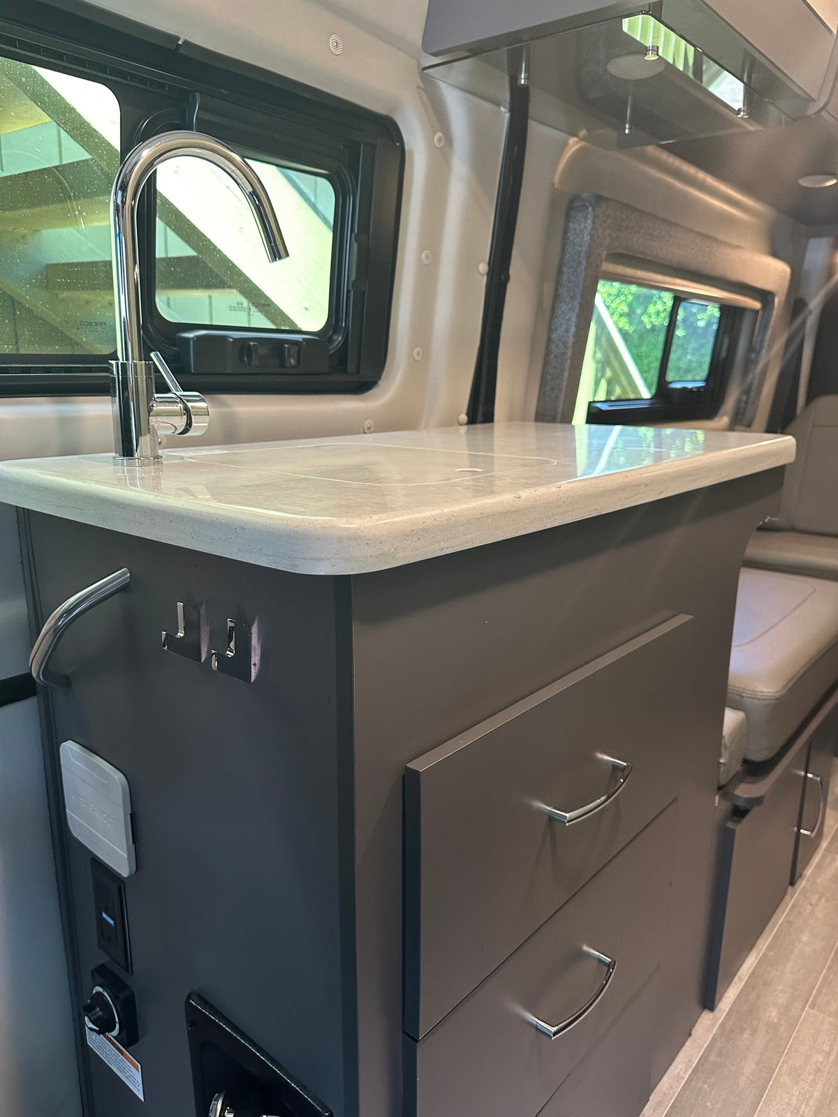  and comfortable bench seating.|This RV rental interior features a stainless steel refrigerator adorned with various stickers and a microwave installed above it — photo 6