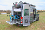 This RV rental camper van features a bed, pull-out bike storage, and roof rack, ready for your next adventure.