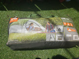Packaged Ozark Trail 3-person dome tent on grass, ideal outdoor gear for camping trips, even with an RV rental.