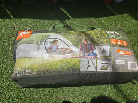 Packaged Ozark Trail 3-person dome tent on grass, ideal outdoor gear for camping trips, even with an RV rental.