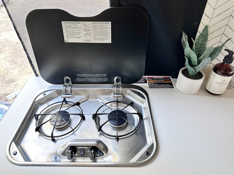  a dining table with stacked bowls & striped napkins. Window view outside.|RV rental interior: open mini-fridge/freezer — photo 17