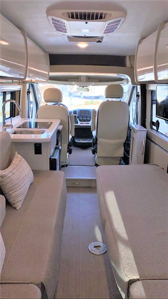  and an open layout view into the living and driver's cab.|RV rental interior features comfortable bench seating — photo 7
