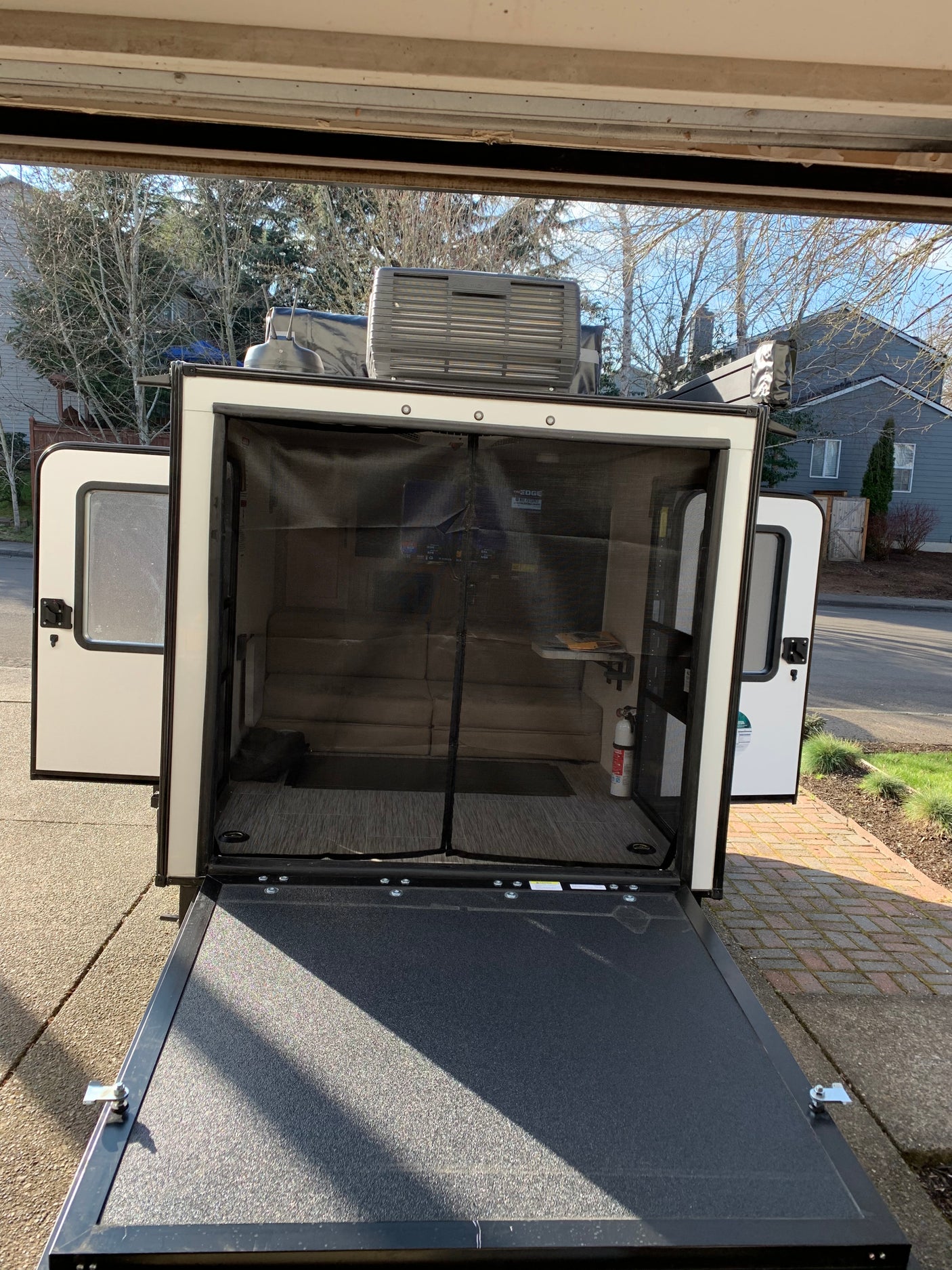 Explore this RV rental's unique features: a lowered rear ramp, screened interior, and rooftop AC, ideal for travel.