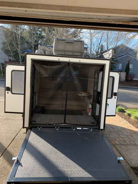 Explore this RV rental's unique features: a lowered rear ramp, screened interior, and rooftop AC, ideal for travel.