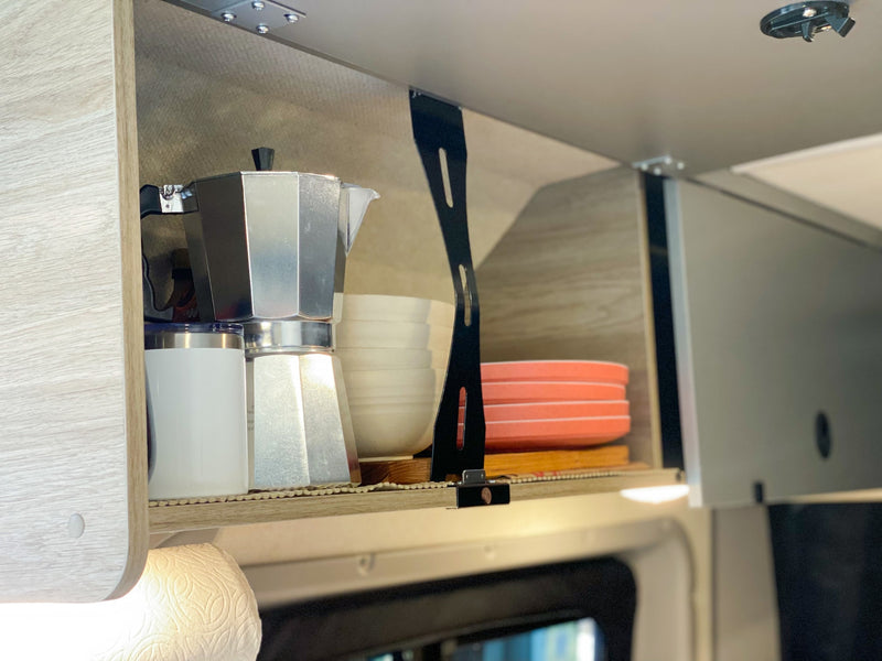 Inside an RV rental: Organized overhead kitchen cabinet with a moka pot, travel mug, bowls, and plates, perfect for camping. — photo 17