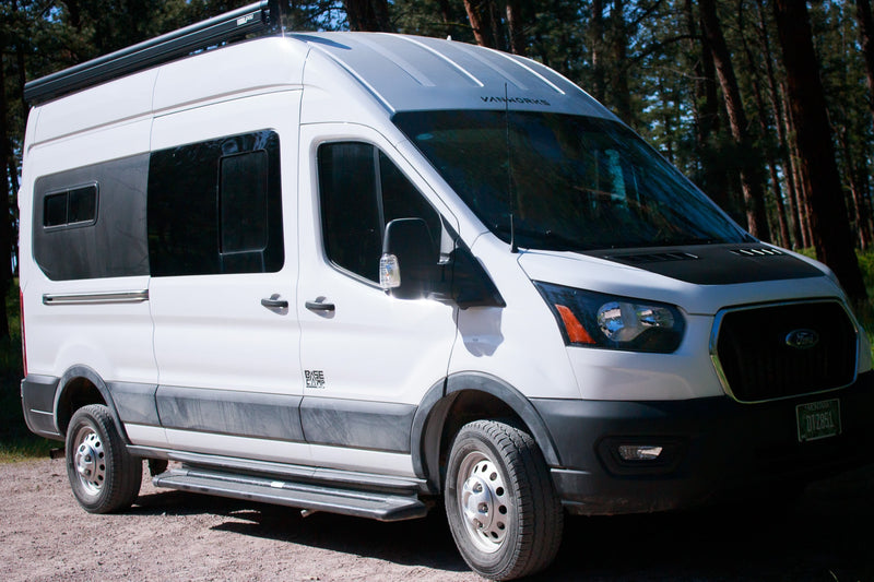 White Ford Transit camper van RV rental, custom-built for adventure, parked on a forest road. — photo 2