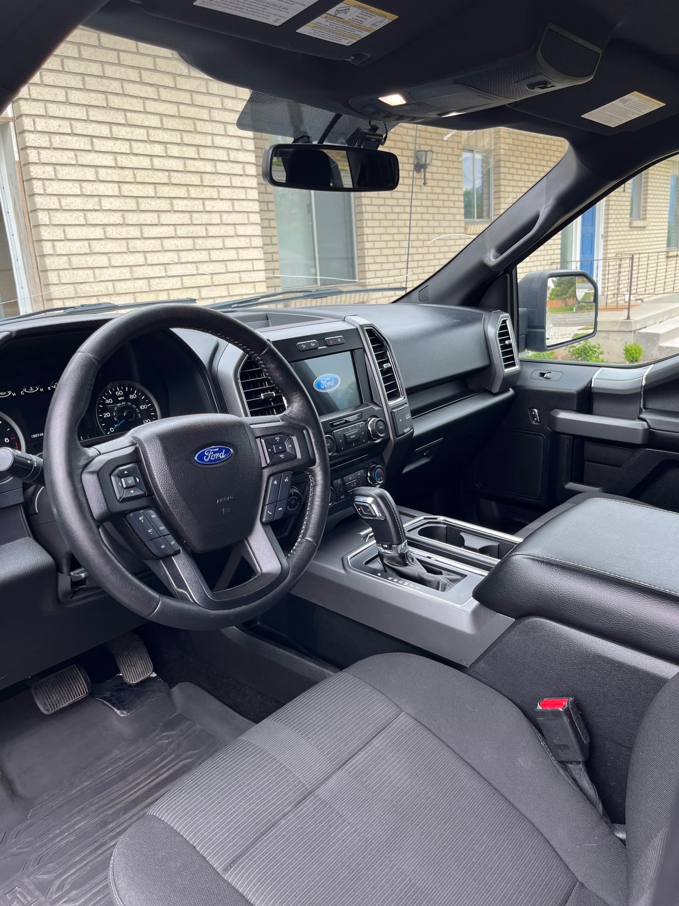 Driver's view inside a Ford truck, ready for an RV rental adventure. Shows the steering wheel, dashboard, and pedals. — photo 12