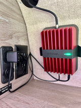A WeBoost cell signal booster connected to 12V power in an RV rental, providing better reception while traveling.