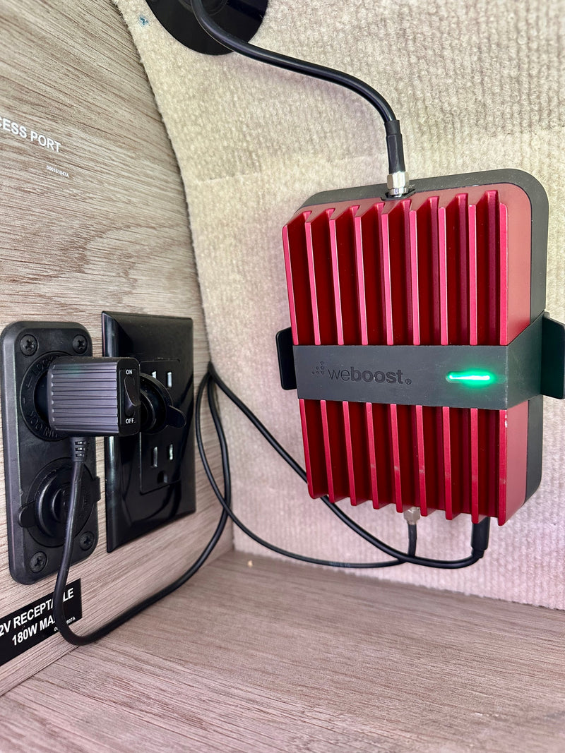 A WeBoost cell signal booster connected to 12V power in an RV rental, providing better reception while traveling. — photo 11